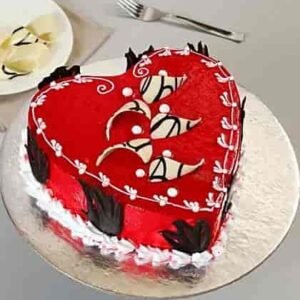 Red Heart Shaped Black Forest Cake with rich chocolate layers, whipped cream, and cherry toppings, ideal for romantic celebrations.