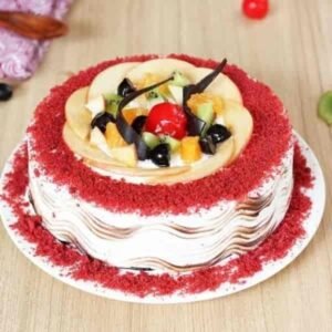 Red Velvet Fruit Cake adorned with fresh fruits and creamy frosting, showcasing a vibrant red hue, ideal for celebrations and gatherings.