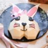 Cute Bunny Pinata Cake decorated with pastel colors and adorable bunny features, ready to reveal a surprise treat inside for celebrations.