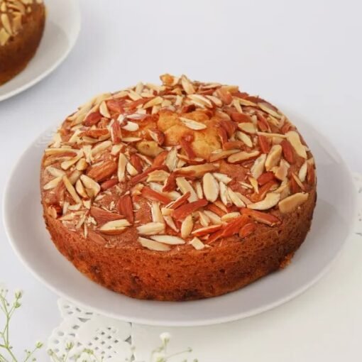 Almond Plum Dry Cake featuring moist layers infused with almond and plum flavors, garnished with sliced almonds for a beautiful finish.