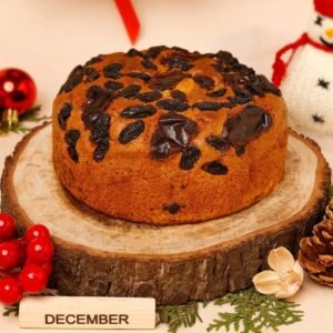 Date & Raisin Delight Cake, a moist cake filled with dates and raisins, garnished with nuts, showcasing its rich texture and sweetness.