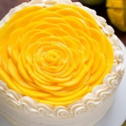 Mango Rose Design Cake, beautifully decorated with intricate mango rose designs and adorned with fresh mango slices, showcasing a vibrant tropical look.