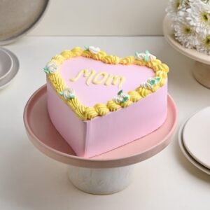 Mom’s Pink Heart Delight cake in a heart shape with pink icing, perfect for Mother's Day celebrations.