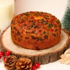 Nutty Date Plum Cake, a rich, moist cake filled with chopped dates and nuts, garnished with a sprinkle of powdered sugar.