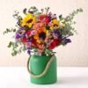 Charming Assorted Blooms in Green Jar with a colorful array of flowers arranged in a rustic green jar for cheerful decor.