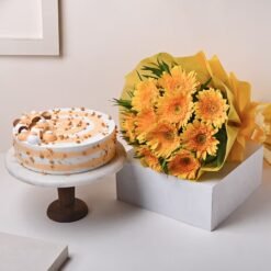 Delicious butterscotch cake topped with caramel accents, paired with a bouquet of bright yellow gerbera flowers.