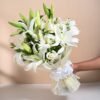 A bouquet of pristine white lilies with lush green foliage, radiating elegance and tranquility.