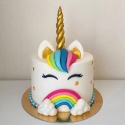 Beautiful unicorn-themed cake with a golden horn, pastel frosting, and floral accents, perfect for birthdays and parties.