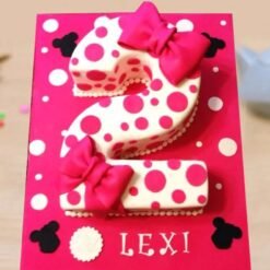 Charming number two-shaped cake featuring Minnie Mouse-themed decorations, pink frosting, and cute polka dot details.