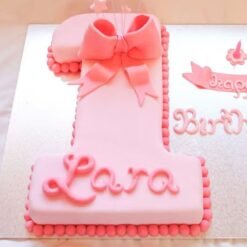 A beautifully designed Pretty In Pink First Cake, adorned with soft pink hues and adorable birthday decorations.