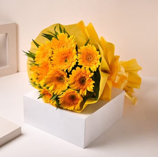 A bouquet of vibrant yellow gerberas with lush green accents, radiating warmth and happiness.